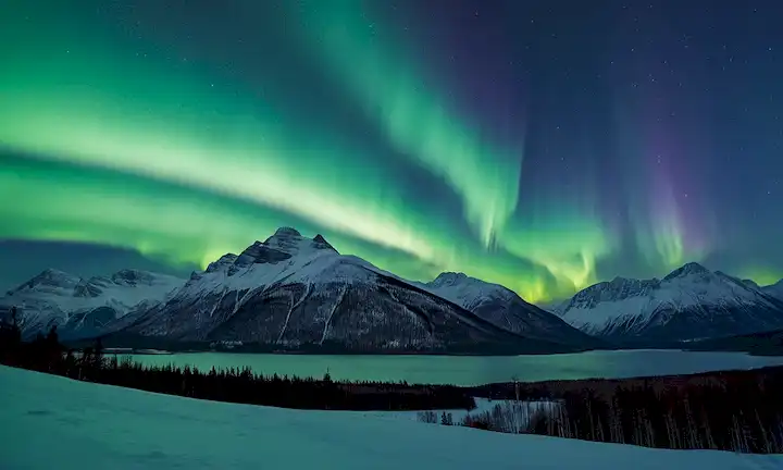 Northern Lights bailando a través del cielo azul oscuro, nubes brillantes iluminadas con suaves tonalidades verdes y azules, montañas malvadas en la distancia, árboles cubiertos de nieve silueta contra una vibrante aurora