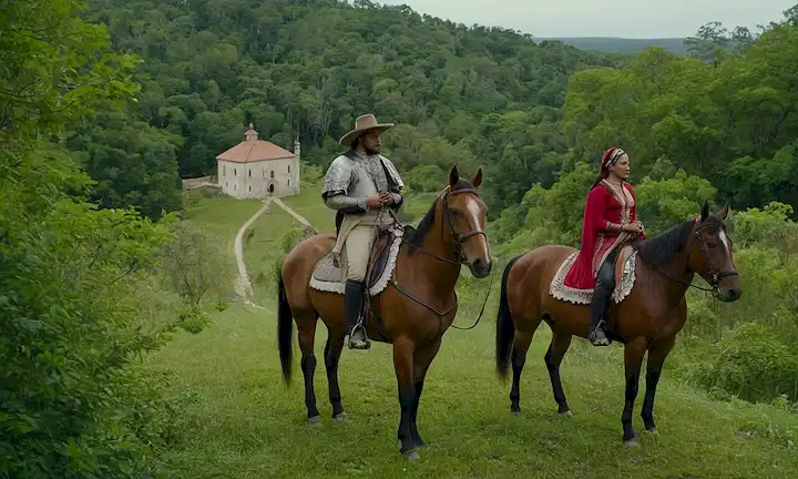 Pueblos indígenas del siglo XVI en América, montando caballos con marcas de raza española, en medio de un exuberante paisaje forestal, con un toque de arquitectura de la era colonial en el fondo, rodeado de plantas y árboles nativos, transmitiendo un sentido de fusión cultural, mezclando tradiciones y hábitos de ambos lados, representando un momento de historia compartida