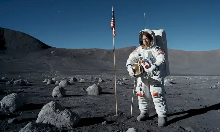 Una foto de Christina Koch de pie en la superficie lunar