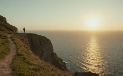 Una persona de pie en el borde de un acantilado con vistas a vastas aguas