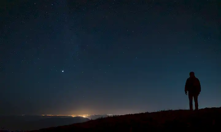 Un cielo oscuro, estrellas brillando débilmente, una fuente de luz tenue en la distancia, una silueta de una persona o objeto en el primer plano, efectos de gradiente sutil, cuerpos celestes visibles a pesar de las sombras, no colores brillantes