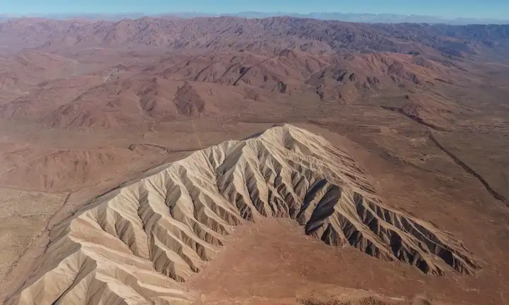 Mapa 3D de Atlas Mountains con indicadores de actividad sísmica, rocas fracturadas y ondas de terremoto visualizadas como ondas onduladas en la superficie, mostrando epicentro, líneas de falla y áreas afectadas en Marruecos y más allá