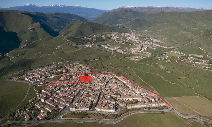 Mapa 3D de España con líneas de falla destacadas en rojo, epicentros de terremotos marcados por círculos azules, y una gran grieta que se abre entre placas tectónicas, montañas temblando en el fondo, paisajes urbanos y edificios desmoronados, personas corriendo por cubierta, señales de advertencia y sirenas visibles en la distancia